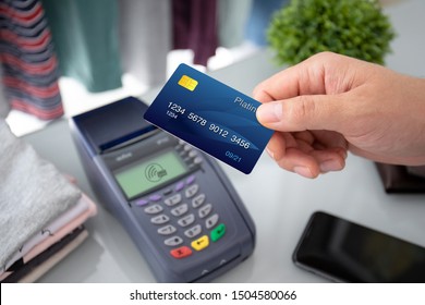 Man Hand Holding Plastic Card And Pay Pass Online Terminal In The Store