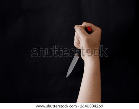Man hand holding a sharp and cutting knife on black background.