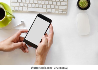 Man Hand Holding Smart Phone With White Blank Empty Screen On White Desk Table.