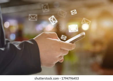 Man hand holding using mobile phone with email icon on screen. Concept of business communication technology.
