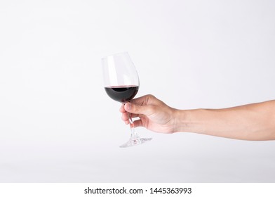 Man Hand Holding A Wine Glass On A Gray Background. 