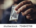 Man hand holds plastic packet or bag with cocaine or another drugs, drug abuse and danger addiction concept, selective focus, toned