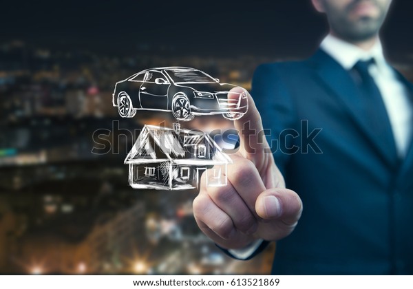 man hand\
house and car in  screen on city\
background