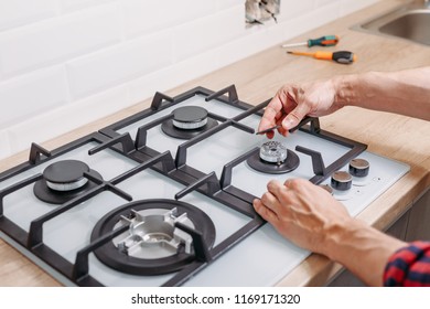 Man Hand Install Burner Ongas Hob In Kithen, Close Up. Repairs Of Gas Control Panel