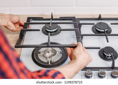 Man Hand Install Burner Ongas Hob In Kithen, Close Up. Repairs Of Gas Control Panel