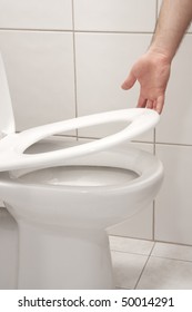 Man Hand Lifting Up A Toilet Seat