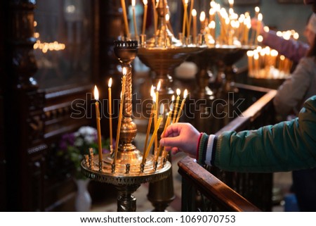 man hand lighting candles in a church