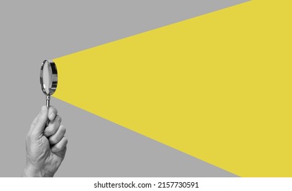 Man hand with magnifying glass. Yellow ray coming from loupe. Conducting check, information search and analysis concept. Spy, accountant, auditor job in abstract style. High quality photo - Shutterstock ID 2157730591