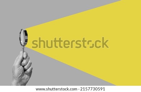 Man hand with magnifying glass. Yellow ray coming from loupe. Conducting check, information search and analysis concept. Spy, accountant, auditor job in abstract style. High quality photo