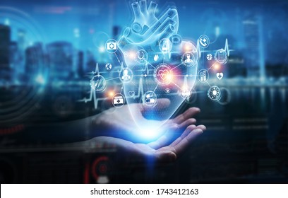 Man Hand On Dark Background Using Digital X-ray Of Human Heart Holographic Scan Projection 3D Rendering