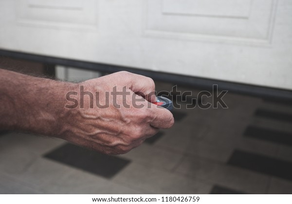 man\
hand open the garage door with remote control\
closeup