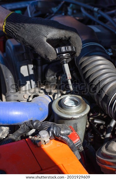 Man hand open power steering cap up for checking\
level of power steering fluid in the system, car maintenance\
service concept.