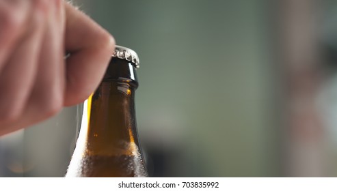 Man Hand Opening Brown Beer Bottle Closeup