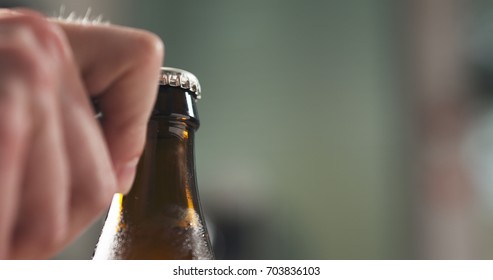 Man Hand Opening Brown Beer Bottle Closeup