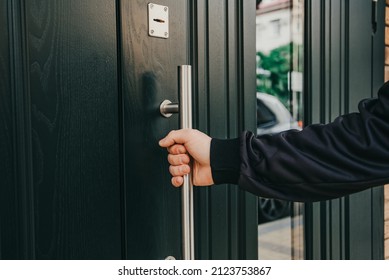 man hand opens a wooden door . pulls on a metal aluminum handle - Powered by Shutterstock