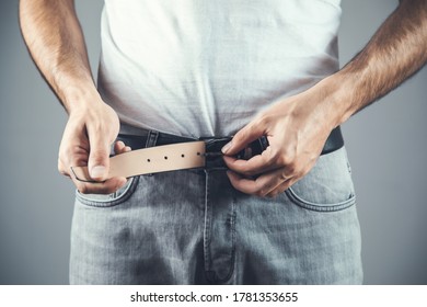 Man Hand Pants Belt On Grey Background