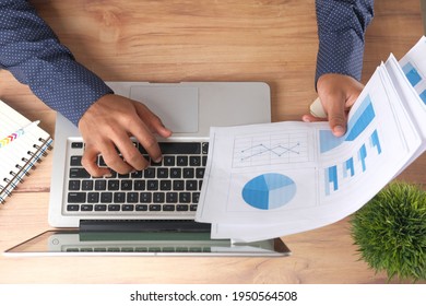 Man Hand With Pen Analyzing Bar Chart On Paper And Using Laptop Top Down 