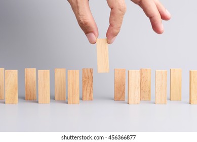 Man hand pick one of wood block from many wood block in row, metaphor to business concept in choose ideal person from many candidate. Gray background, side view. - Shutterstock ID 456366877