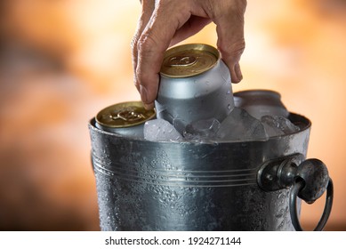 Man Hand Picking Cold Beer Can From Ice Cooler Tank