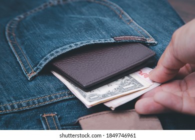 The Man Hand Picking Up The Money In The Wallet That Put In The Jeans.