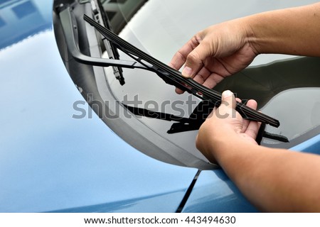 man hand picking up windscreen wiper or Mechanic check old wiper blade on customers sedan car. 