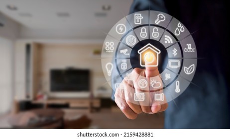 Man Hand Point Smarth Home GUI In Livingroom. Hand Use Smart Screen Smart Home Automation Assistant On A Virtual Screen And A User Touching A Button