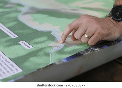 Man hand pointing at map during business meeting. focused professional working on project planning and strategy, showing specific direction and key location