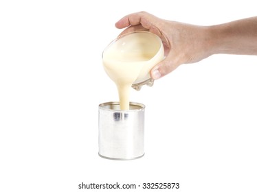 Man Hand Pouring Condensed Milk Into A Tin Can Isolated