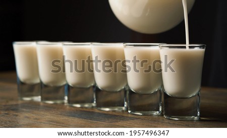 Man Hand Pouring Milk Alcohol Into Glasses