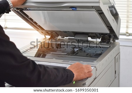 Man hand press start button on panel 
of Photocopier, Copier machine.