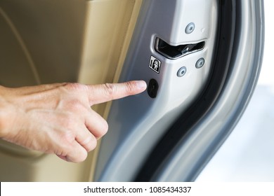 Man Hand Pressing On Child Lock Button At Car's Door.