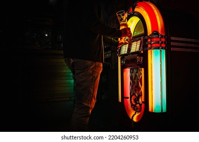 Man Hand Pushing Buttons To Play Song On Old Juke Box, Selecting Records In Bar