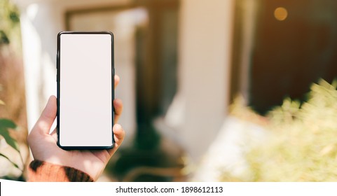 A Man Hand With Red Sweater Are Holding A Mockup Of Vertical Black 5g Mobile Smartphone With Blank White Screen For Insert Your Design, Digital Global Communicate By Smart Phone, Clipping Path Include