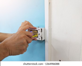 Man Hand Repairing Digital Heating And Cooling Thermostat. Thermostats On Blue And White Background.HVAC Technician Repairing Digital Heating And Cooling Thermostat.