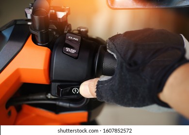 Man hand rider in a Motorcycle Gloves holding handlebar and pressing the Start,Stop Engine Buttons on motorcycle in garage,Things To Do Before Starting motorcycle concept