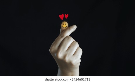 Man hand shaped mini heart to the smiley face emoticon  with two hearts.valentine's day - Powered by Shutterstock