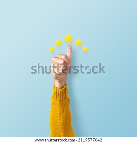 Man hand showing thumb and giving a five star rating on pink background. Service rating, feedback, satisfaction concept