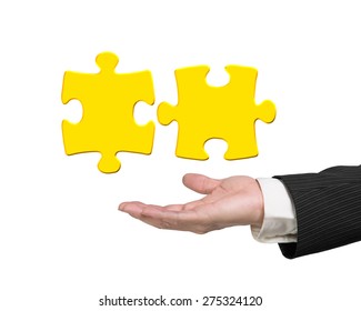 Man Hand Showing Two 3D Gold Jigsaw Puzzle Pieces Isolated On White Background