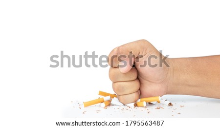 Man hand smash cigarette on white background, Man's fist crushing cigarettes, Stop smoking initiative concept of breaking cigarettes, World no tobacco day.