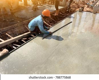 man hand spreading concrete mix with trowel in foundation. A construction worker is pouring cement and concrete,Selective focus.