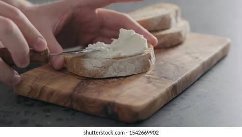 Man Hand Spreading Ricotta On Slice Of Ciabatta