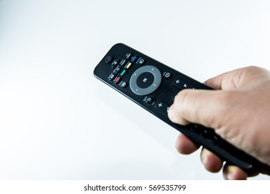 Man hand with television remote control isolated on white background - Shutterstock ID 569535799