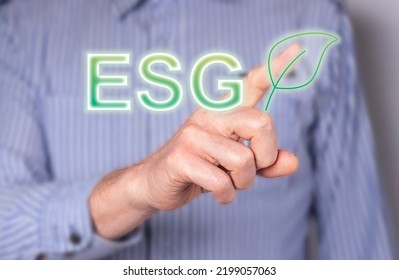 Man Hand Touching ESG Abbreviation With Leaf At Digital Screen. Doing Business With Focus On Environmental Standards, Natural World Preservation. High Quality Photo