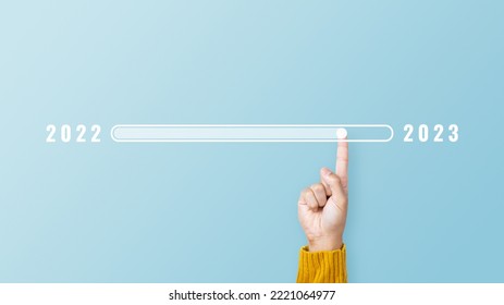 Man hand touching loading bar for countdown to 2023. Loading year 2022 to 2023. Start concept