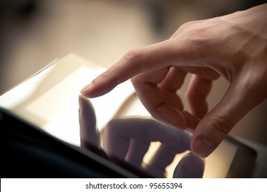 Man hand touching screen on modern digital tablet pc. Close-up image with shallow depth of field focus on finger.