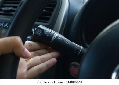 Man Hand Use The Signal Switch. Car Interior Detail With Blue Light.