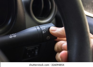 man hand use the signal switch. Car interior detail with worm light.