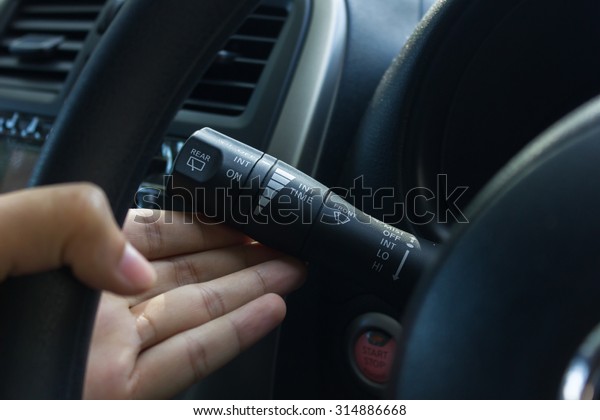 man hand use the signal switch. Car interior\
detail with blue light.