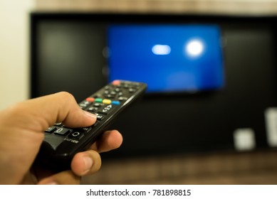 man hand using remote control open the television  in room