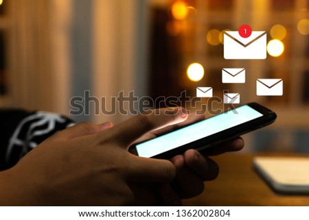 a man hand using smartphone and it's show 1 email recieve.icon pop up on screen of mobile phone. Business communication technology concept.